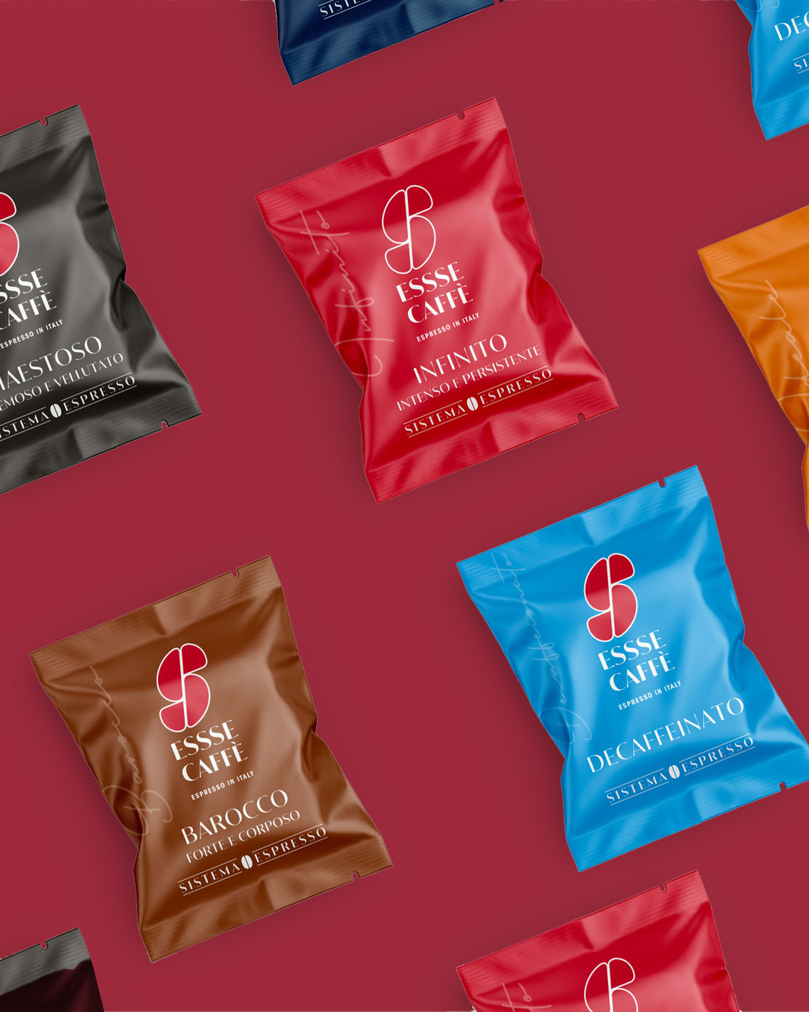 Confezioni monodose essse caffe infinito barocco decaffeinato e maestoso disposte su sfondo rosso