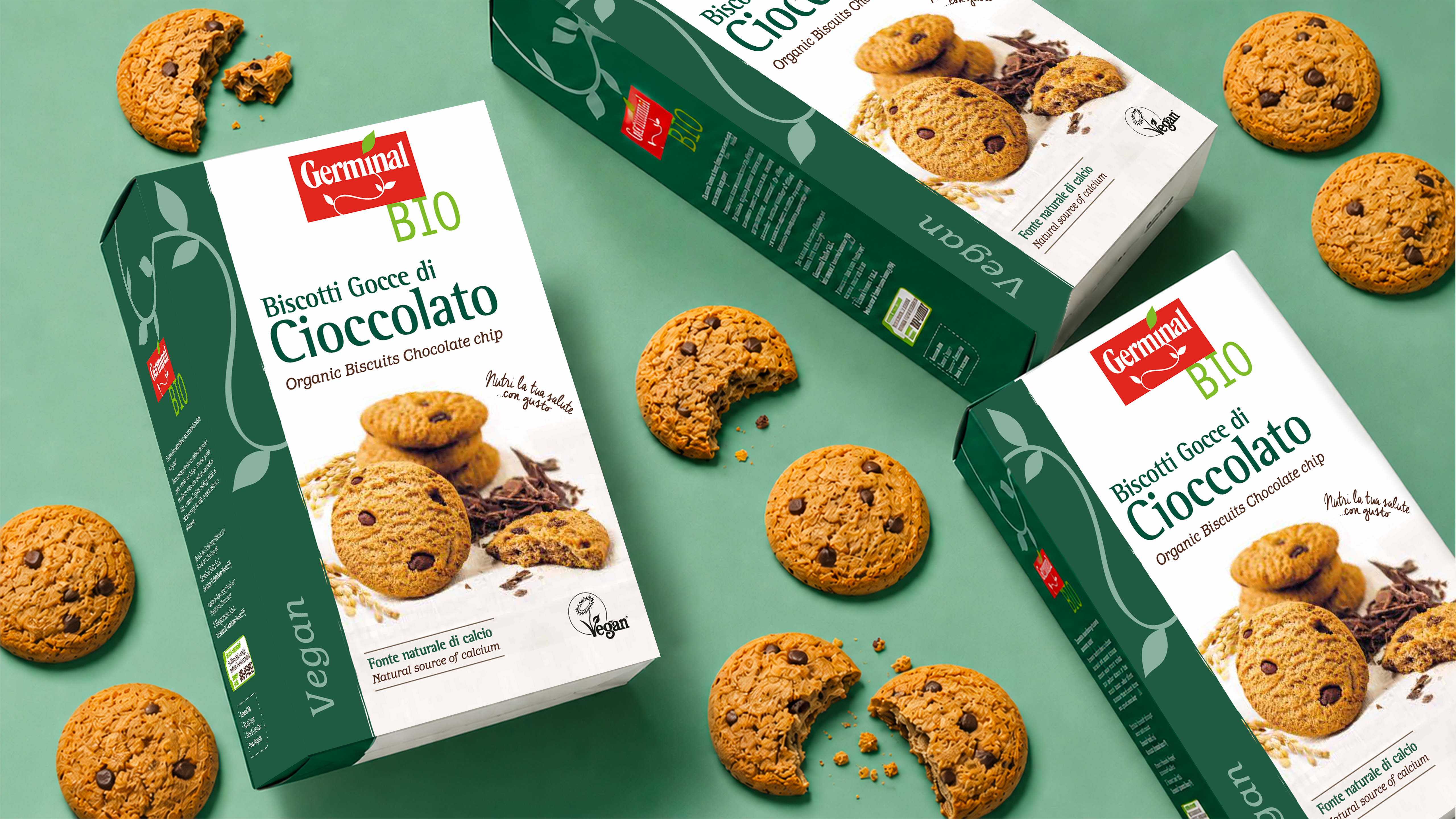 Confezioni germinal bio di biscotti vegan con gocce di cioccolato circondate da biscotti interi e spezzati su sfondo verde