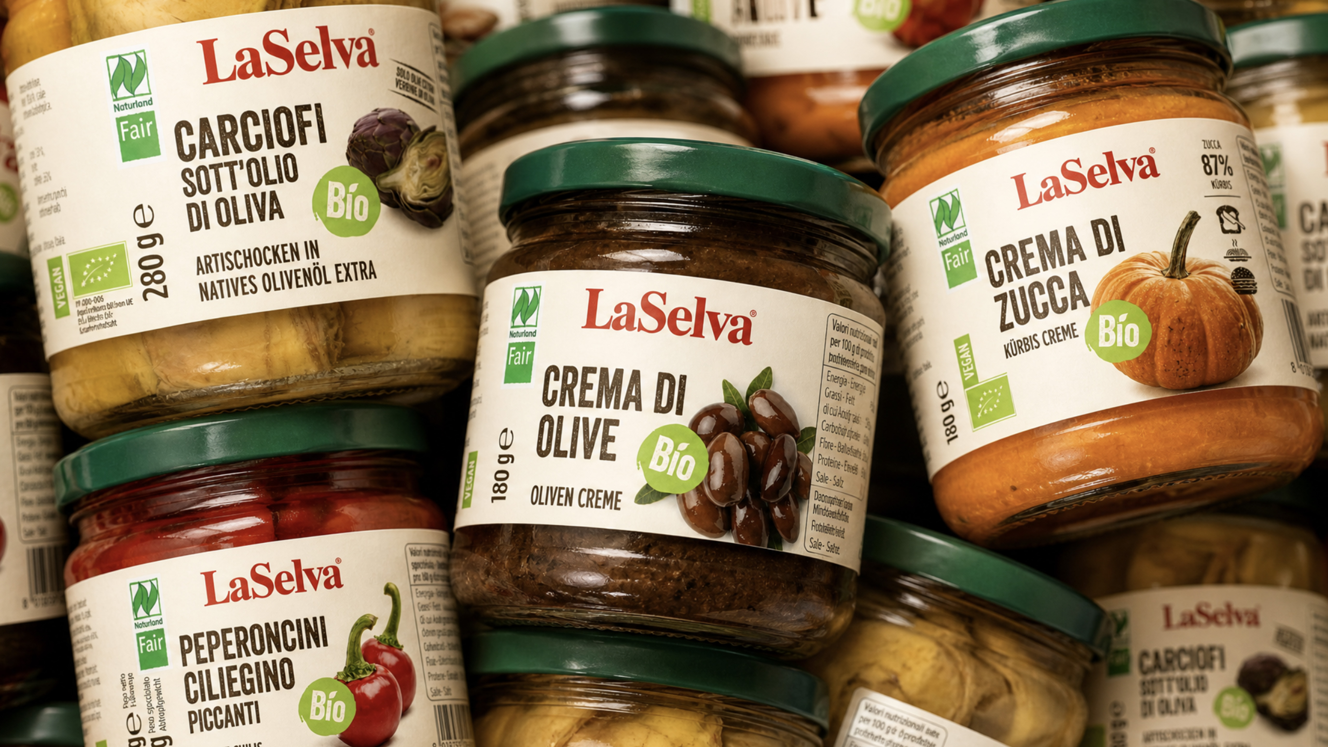 Barattolo laselva di crema di olive biologica con coperchio verde tra altre confezioni del prodotto