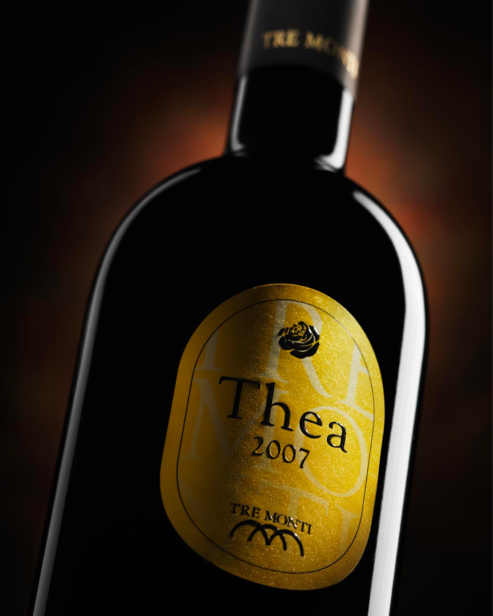 Bottiglia di vino thea 2007 tre monti con etichetta dorata su sfondo scuro