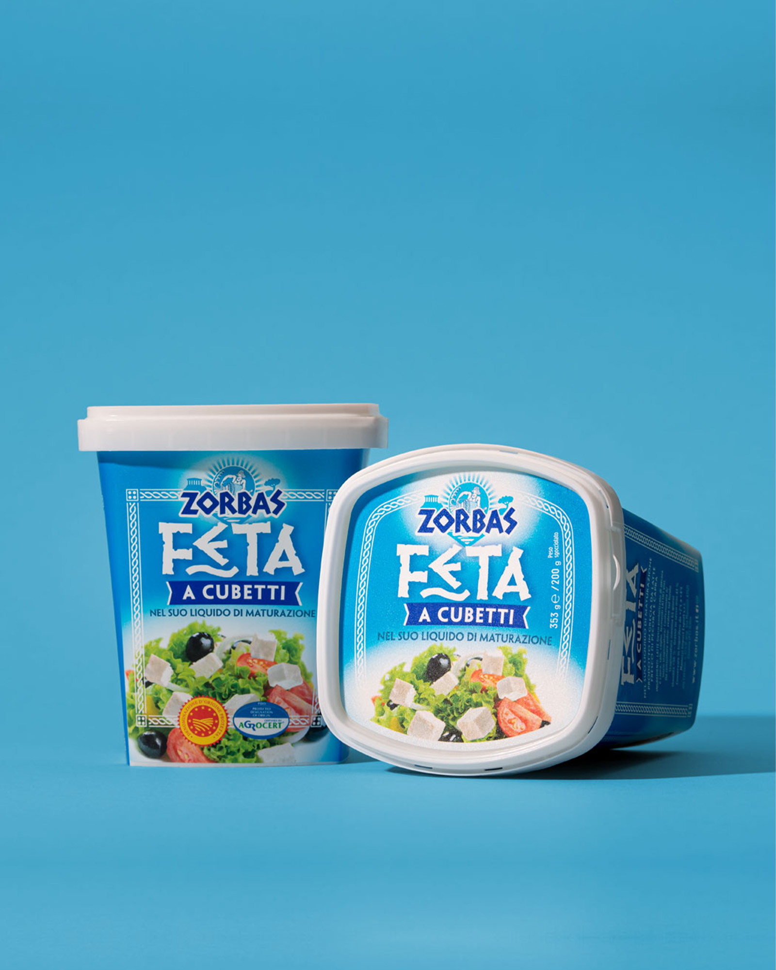 Confezioni zorbas di feta a cubetti disposte su sfondo azzurro
